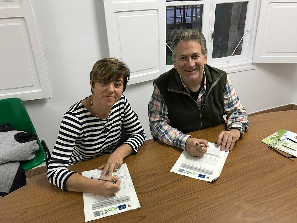 La presidenta de la Junta Vecinal de Pámanes, Ana Isabel Ríos Barquín, y el presidente de Fundación Naturaleza y Hombre, Carlos Sánchez, firman el acuerdo para la gestión de los Pozos de Valcaba.